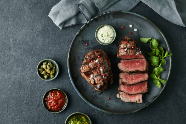 tasty steak on a black plate on a dark modern table - steak grilled beef plate imagens e fotografias de stock