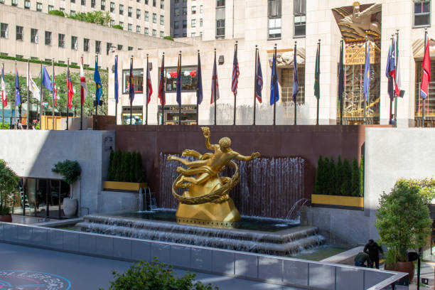 Prometheus sculpture at Rockefeller Center in New York City New York City, New York, USA - July 19, 2022: Daytime view of  the Prometheus statue, a gilded bronze sculpture by artist Paul Manship, located above the lower ice rink plaza at Rockefeller Center in New York City. rockefeller ice rink stock pictures, royalty-free photos & images