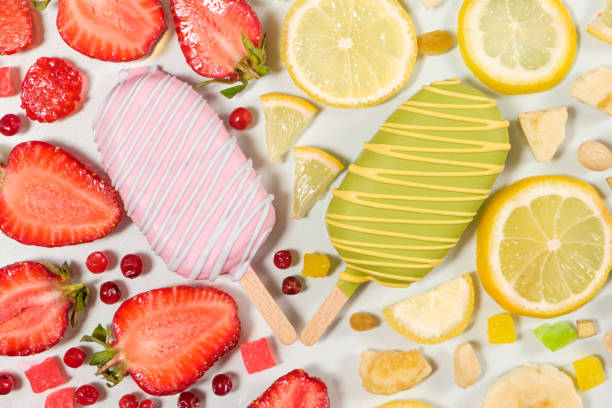 Two ice creams on a sticks - strawberry and lemon on a white background.