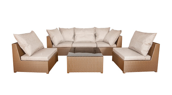 Set of wicker rattan furniture for the garden or terrace. comfortable sofa and two armchairs with soft pillows and a coffee table.