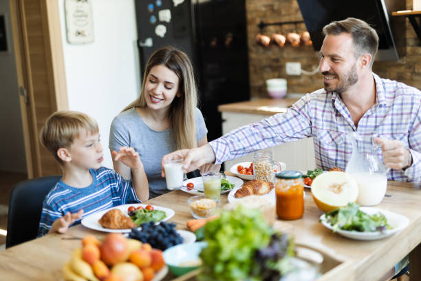 istock Happy family  talking during breakfast time at dining table 1411848122