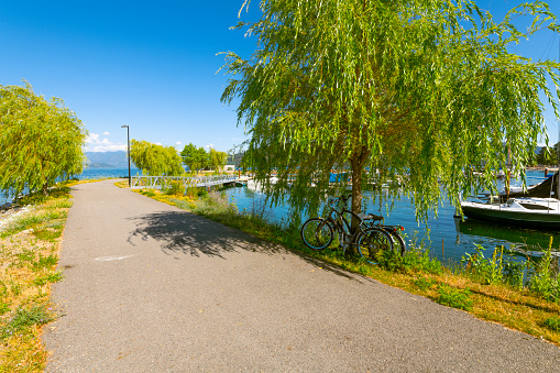 Two bicycles are parked along a walking trail around the Sandpoint, Idaho city beach and marina on Lake Pend Oreille in the Idaho panhandle.
