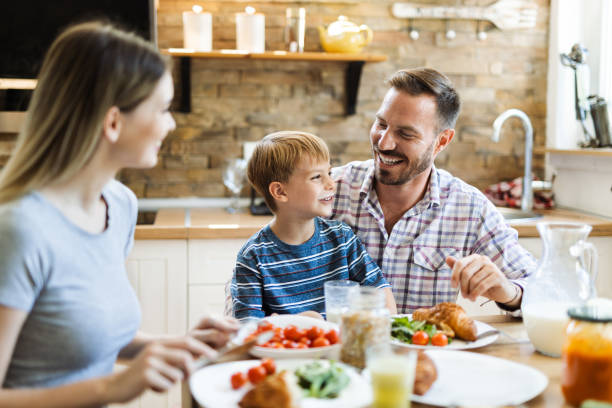 istock Happy family having fun during breakfast time  in the kitchen 1411849047