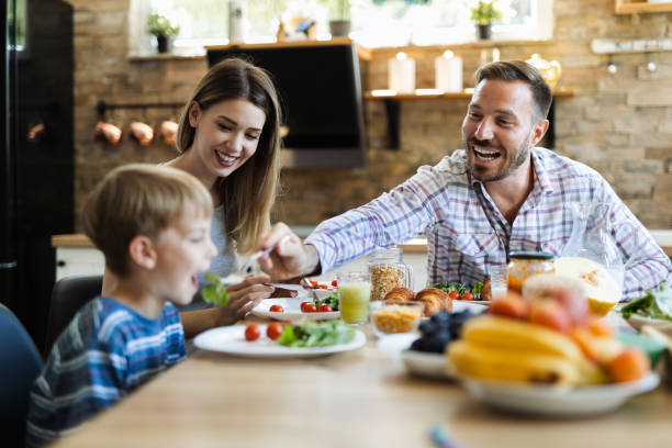 istock Happy father feeding her son  in dining room 1411849103