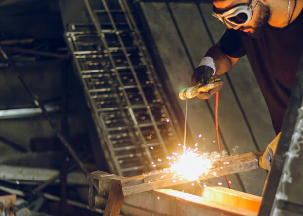 istock Professional worker Welding metal at workshop with electric welding rod 1411850287