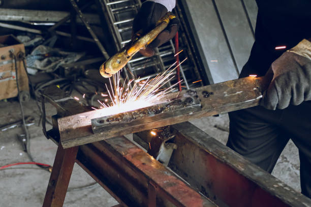 istock Professional worker Welding metal at workshop with electric welding rod 1411850474