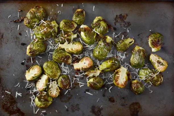 Roasted Brussels Sprouts with grated parmesan cheese. Horizontal format form a high angle.