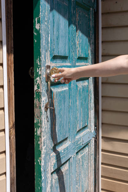istock female hand opens an old wooden door 1411853438