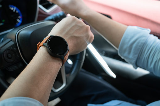 Freelance trader Holding watching on smart watch while driving a car