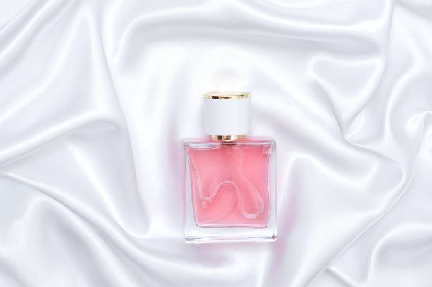istock Perfume bottle on folded silk fabric background. Women's perfume cosmetic product 1411865611