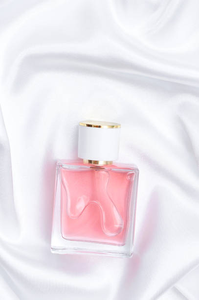istock Perfume bottle on folded silk fabric background. vertical photo 1411865636