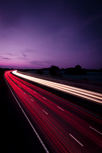 Fast moving traffic on M25 motorway at night, London, England, United Kingdom, Europe