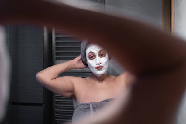 dojrzała arabska kobieta w lustrze w domu z zabiegami estetycznymi i kosmetycznymi do pielęgnacji ciała i skóry. koncepcja wellness i osobistej akceptacji. - mirror women kissing human face zdjęcia i obrazy z banku zdjęć