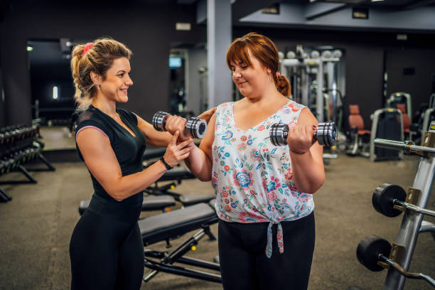 istock Plus-size woman exercising with her instructor 1411870228