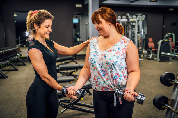 istock Personal trainer helping a plus-size woman 1411871654
