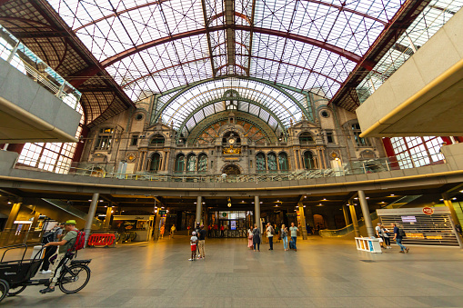 panoramic view of the interior of the Moynihan Train Hall, an expansion of Penn Station in the James Farley Building,  the main  commuter rail station in NYC.