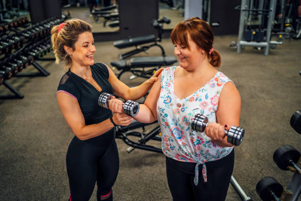 istock Female gym instructor giving instructions in gym 1411872530