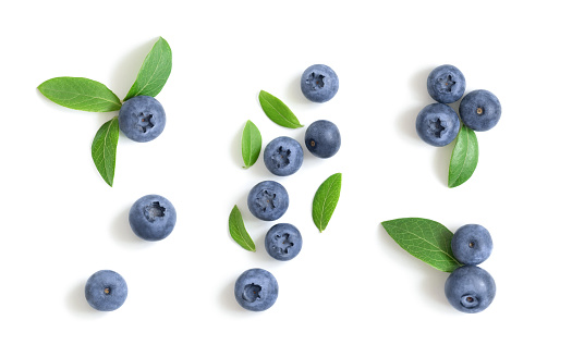 Set of blueberries isolated on a white background. Blueberry berries with green leaves. Bilberry, huckleberry. Top view, flat lay.