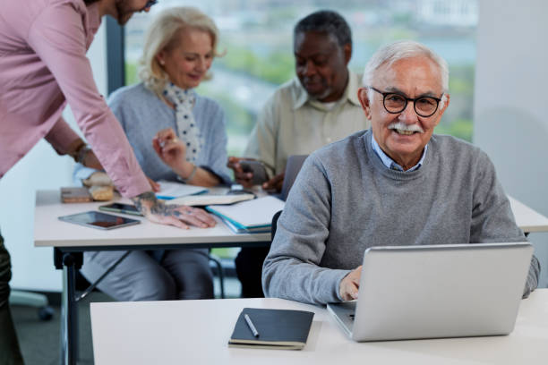 istock A senior man is smiling while having a retraining class with a multicultural group of senior people in the classroom. 1411881009