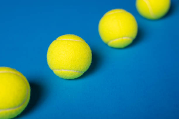 istock Tennis Balls Inline on Blue Background 1411881185