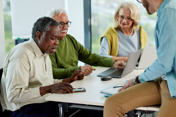 istock Young hipster educator teaching group of senior multiracial people using technology and the internet in the classroom. 1411881205