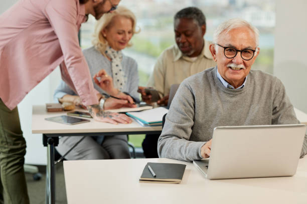 istock A senior man is smiling while having a retraining class with a multicultural group of senior people in the classroom. 1411882054