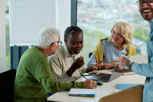 istock Multicultural group of senior students asking questions their tutor who showing them solution. 1411882195