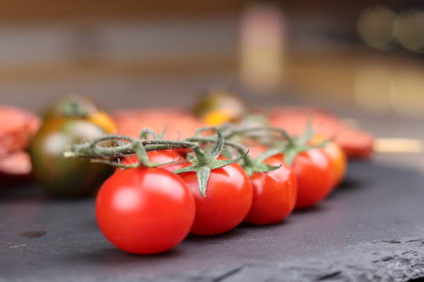 красные помидоры черри выстроились вплотную и далеко в идеальной гармонии, фон разрушен. - green tomato black krim tomato cherry tomato tomato стоковые фото и изображения