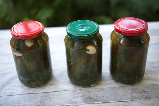 The process of canning pickled gherkins for the winter, pickles cucumbers in glass jars close-up.