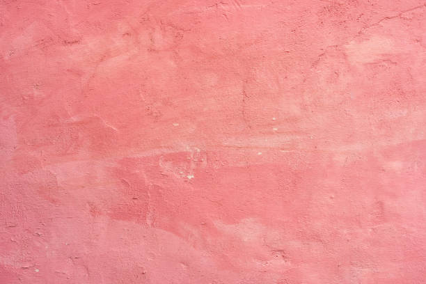 istock Old cement wall painted pink with peeling paint 1411888117