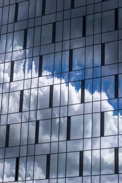 Photo of Reflection in the building blue sky with light clouds