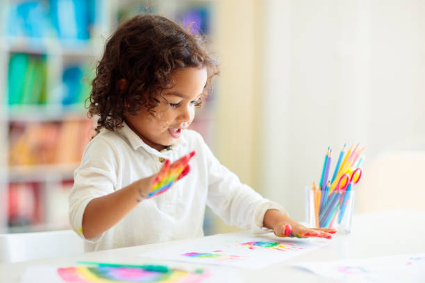istock Child drawing rainbow. Paint on hands. 1411893471