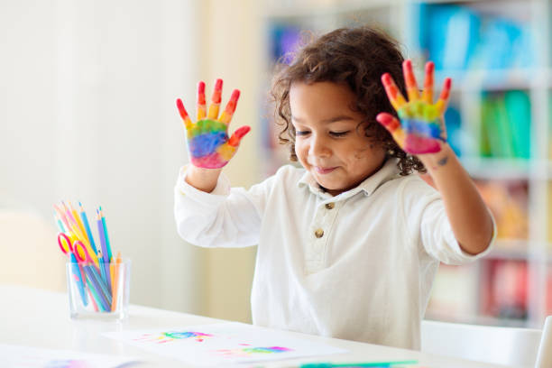 istock Child drawing rainbow. Paint on hands. 1411895329
