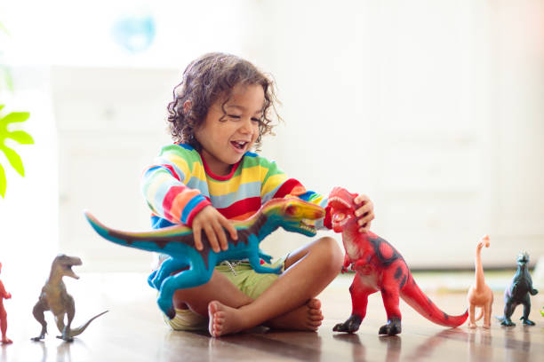 enfant jouant avec des dinosaures de jouet. jouets pour enfants. - childs toy photos et images de collection
