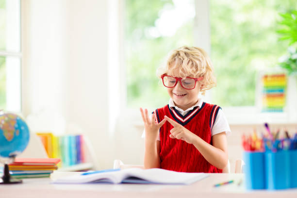 Kids go back to school. Children study and learn for preschool. Little boy of elementary class doing homework. Bedroom with desk, books and globe for young child. Kid learning to read and write.