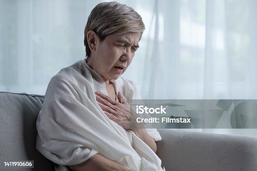 istock Senior Asian woman suffering from heart attack while alone at home. 1411910606
