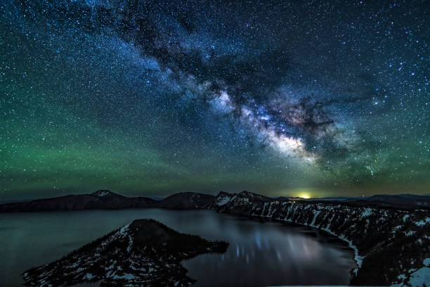 Milky Way Reflected by Crater Lake A brilliant Milky Way reflects in Crater Lake, captured on the Summer Solstice in Crater Lake National Park, Oregon. milky way stock pictures, royalty-free photos & images