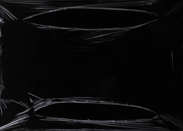 istock a black transparent plastic texture with hole for poster and cover art. realistic plastic wrap for overlay, copy space and photo effect. wrinkled plastic surface on black background 1411917231