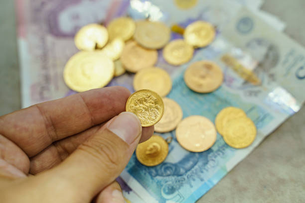 istock Large group of Gold coins with British Pound Notes and Coins 1411917402