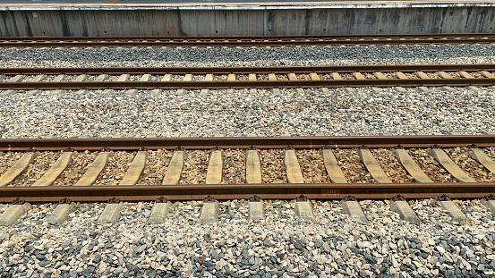 Selective focus, diagonal view of trail tracks in the Swiss alps. The middle track is known as a cog wheel and help train go up and down mountains.