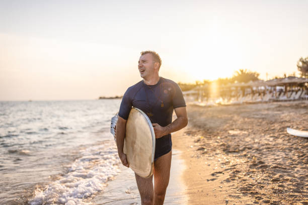 istock Surfer man walking at the beach 1411920153