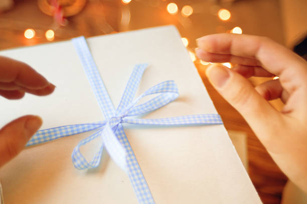 istock Woman's hands opening Christmas gift box. 1411921680