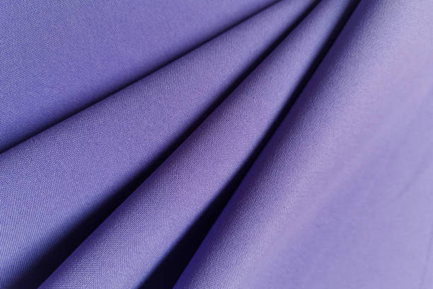 istock Violet crumpled or wavy fabric texture background. Abstract linen cloth soft waves. Gabardine wool fabric. Merino yarn. Smooth elegant luxury cloth texture. Concept for banner or advertisement 1411928116