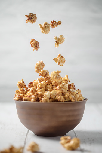 Pouring caramel popcorn on to a big bowl
