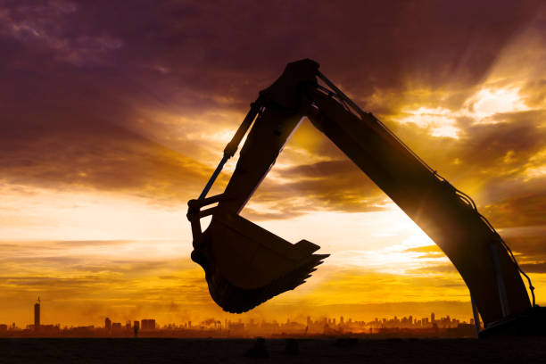 istock Silhouette of excavator bucket in construction site 1411933027