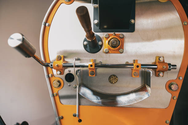 крупный план кофеобжарочной машины в небольшом производстве кофе - roasted machine bean mixing стоковые фото и изображения