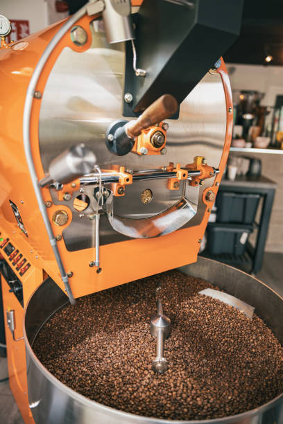 primer plano de la máquina de tostado de café con granos de café en la fabricación de café pequeño - roasted machine bean mixing fotografías e imágenes de stock