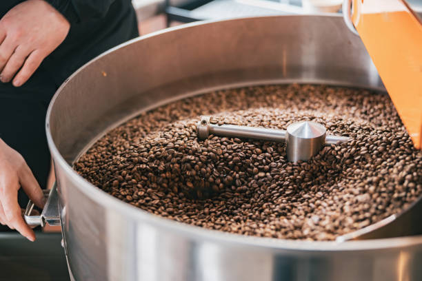 istock Close up of worker hands roasting coffee beans in roasting machine 1411933404