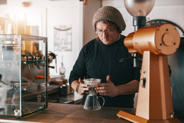 istock Men barista making a drip filter coffee standing by counter in coffeeshop 1411933405