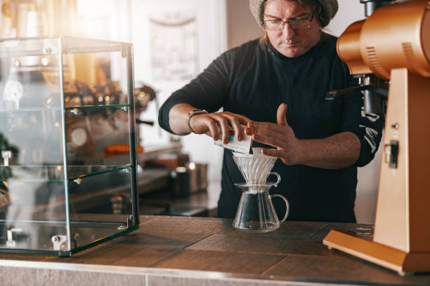 istock Men barista making a drip filter coffee standing by counter in coffeeshop 1411933435